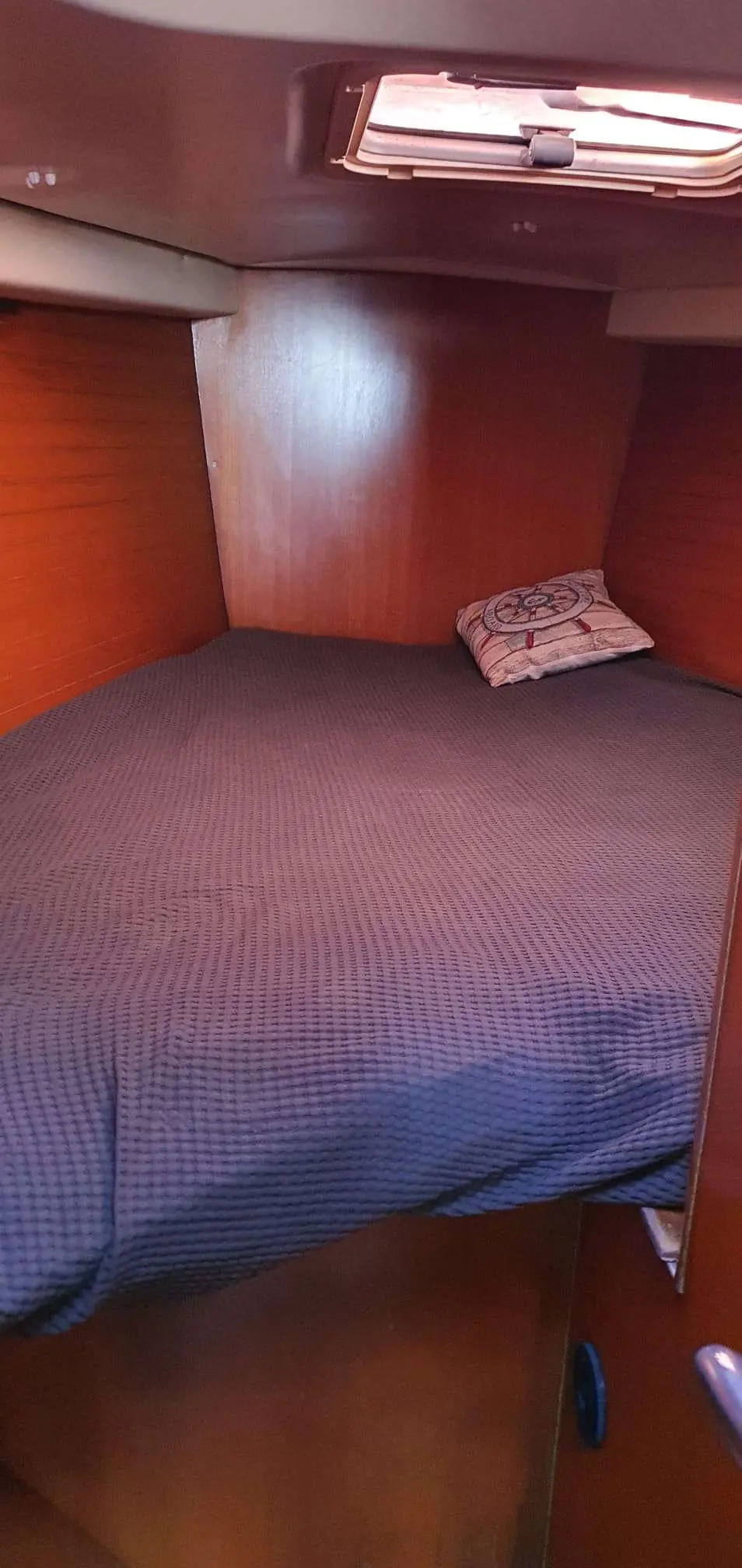 Grand Soleil 44 — Couchette intérieure avec literie, boiseries et hublot.