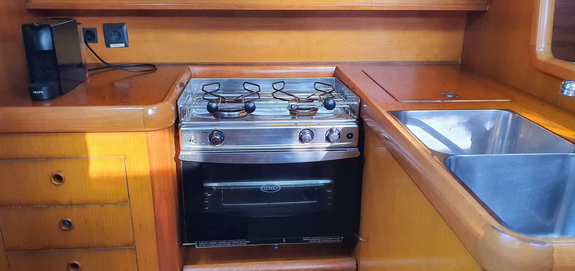 Grand Soleil 44 — Cuisine intérieure avec cuisinière, four et évier en inox.