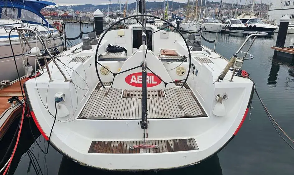 Beneteau First 44.7 — Vue arrière du cockpit et du pont d’un voilier amarré dans une marina.