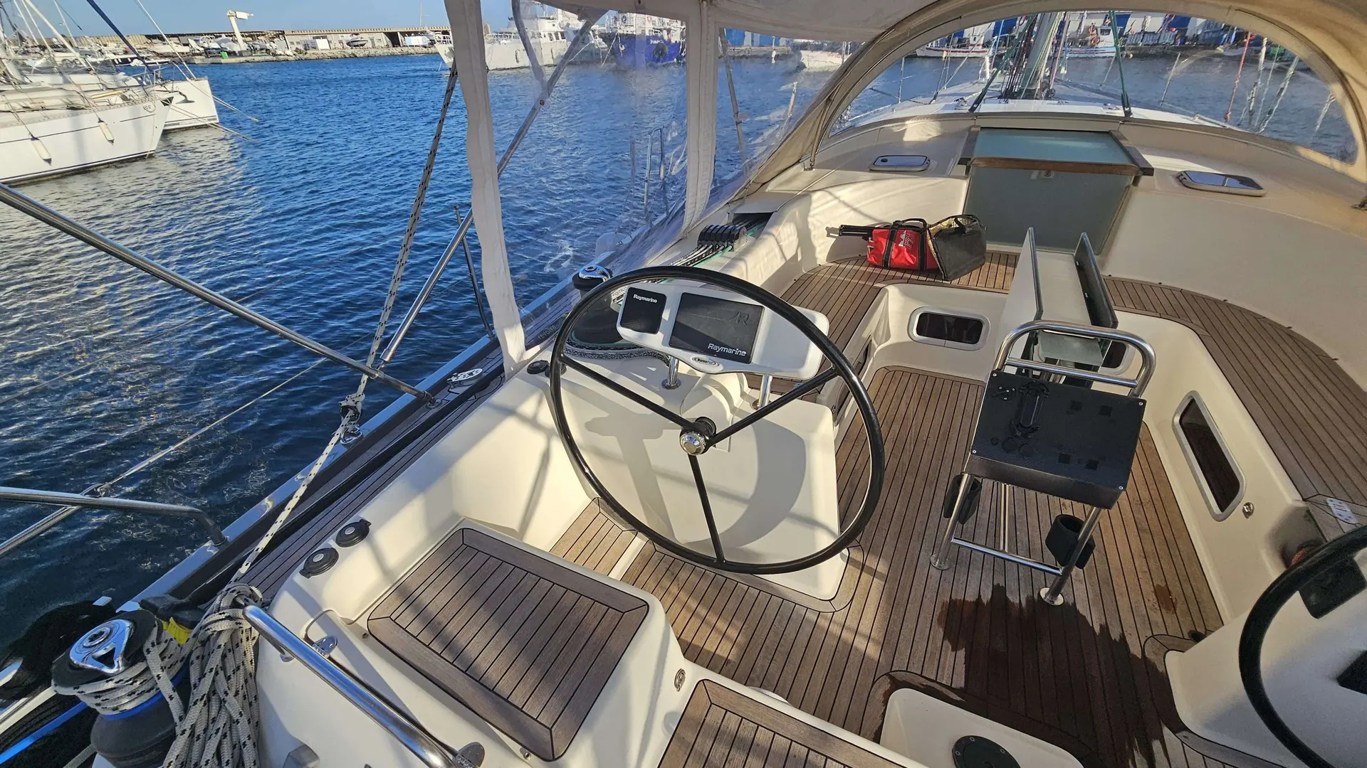 Hanse 531 — Vue du cockpit et de la barre d’un voilier amarré dans un port.