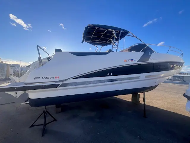 Beneteau Flyer 8.8 SUNdeck — Bateau à moteur blanc vu de trois quarts, posé sur bers dans un port.