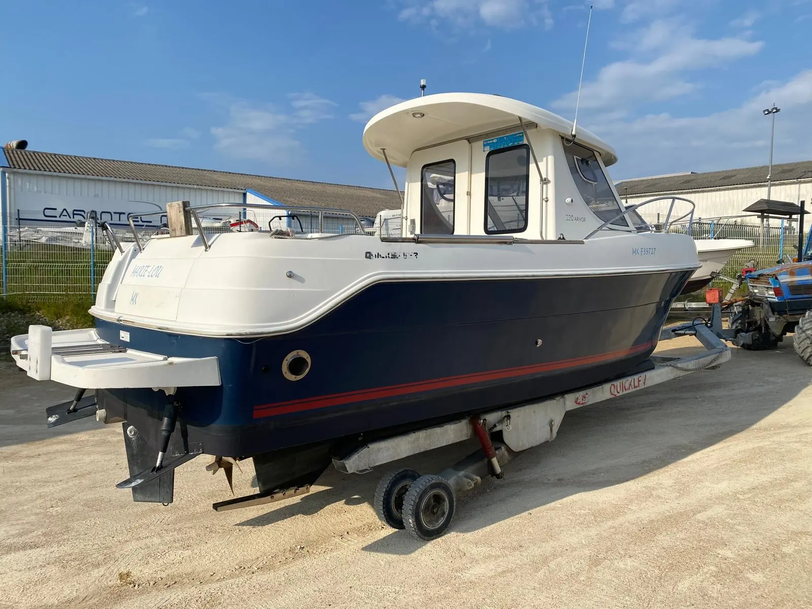 Arvor 230 — Bateau de pêche à cabine présenté sur sa remorque dans une zone nautique.