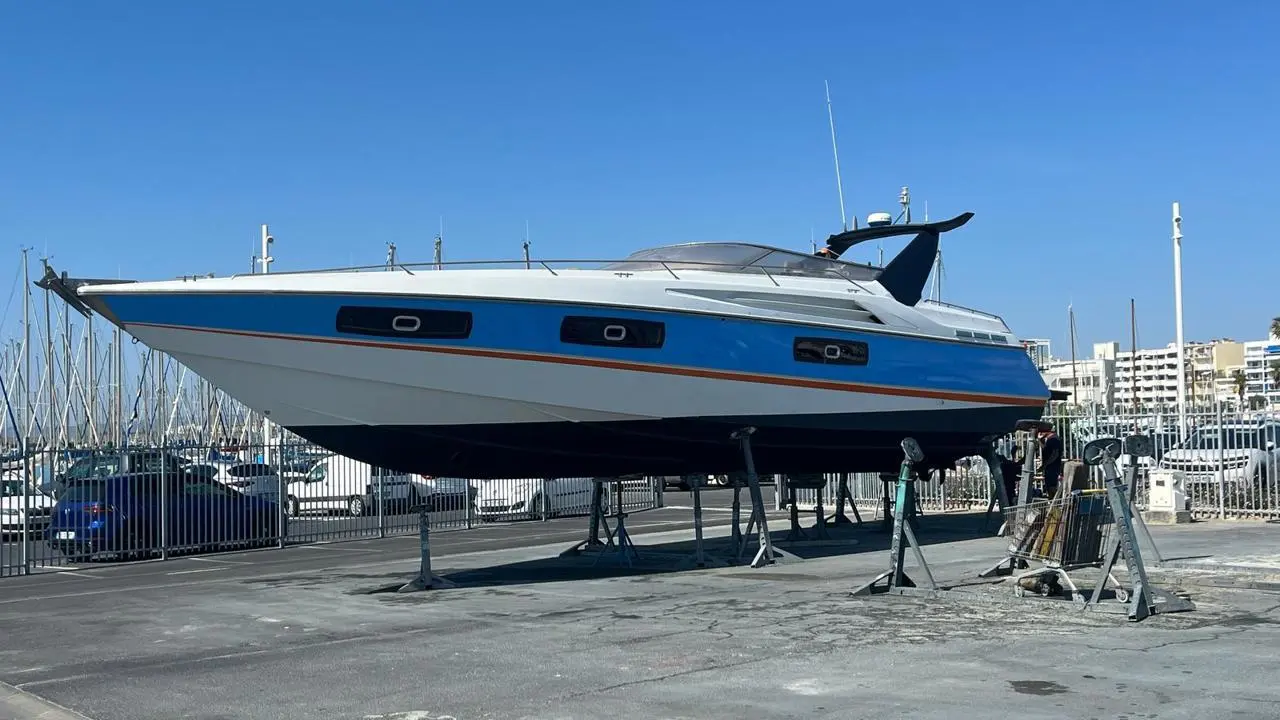 Sunseeker Superhawk 50 — Bateau à moteur bleu et blanc photographié à sec dans un port.