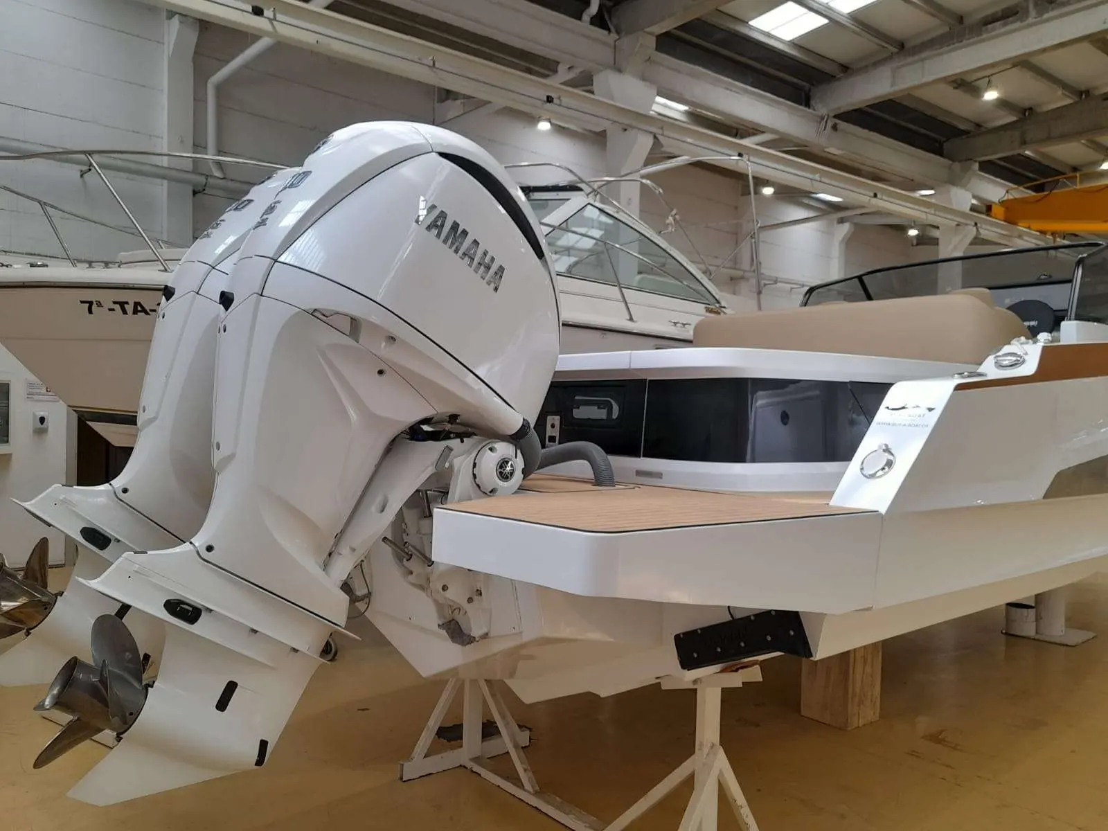 Sterk 31 RC — Vue arrière d’un bateau exposé en intérieur, avec un moteur hors-bord.