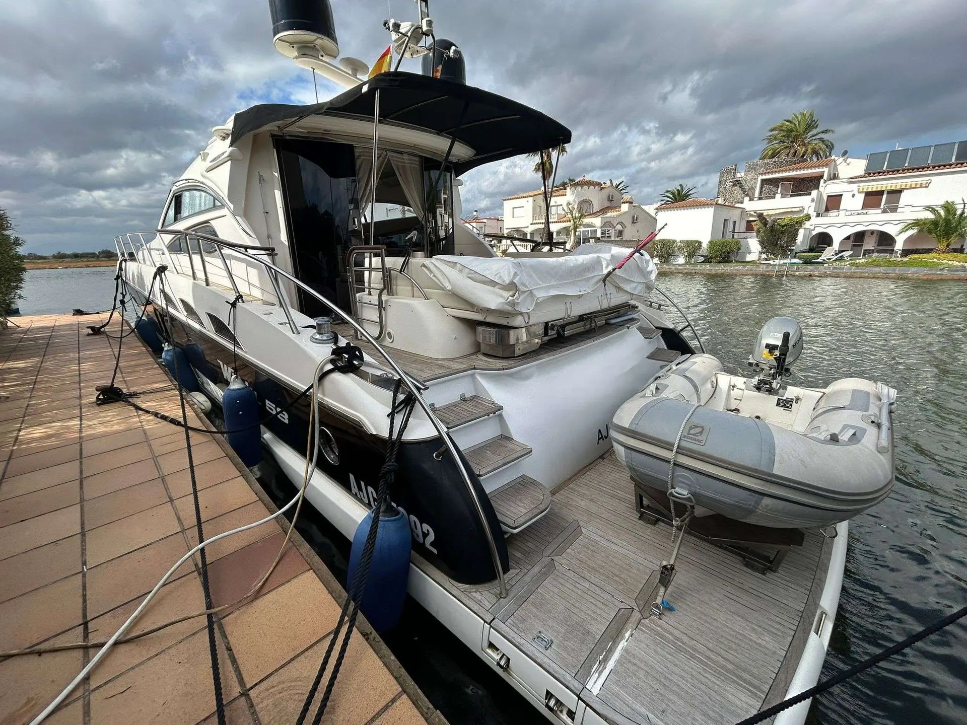Windy 58 Zephyros — Bateau à moteur amarré au ponton, vu depuis l’arrière tribord, avec annexe.
