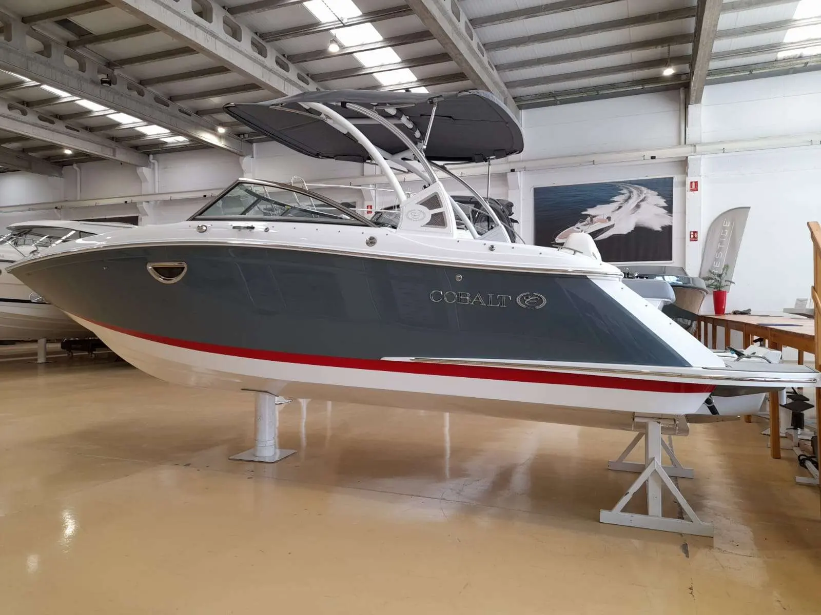 Cobalt 25 SC — Bateau à moteur présenté sur ber, vu de profil dans un hall couvert.