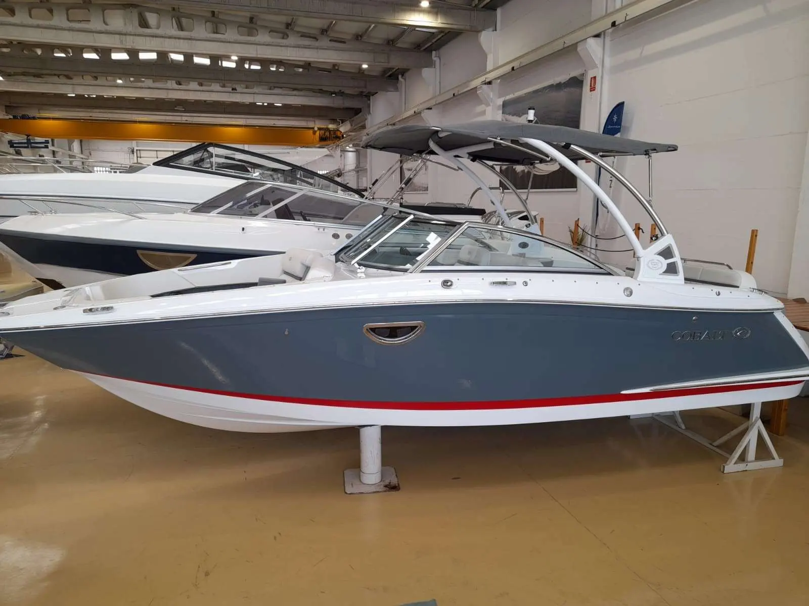 Cobalt 25 SC — Bateau à moteur bleu et blanc présenté sur berceau dans un hangar.