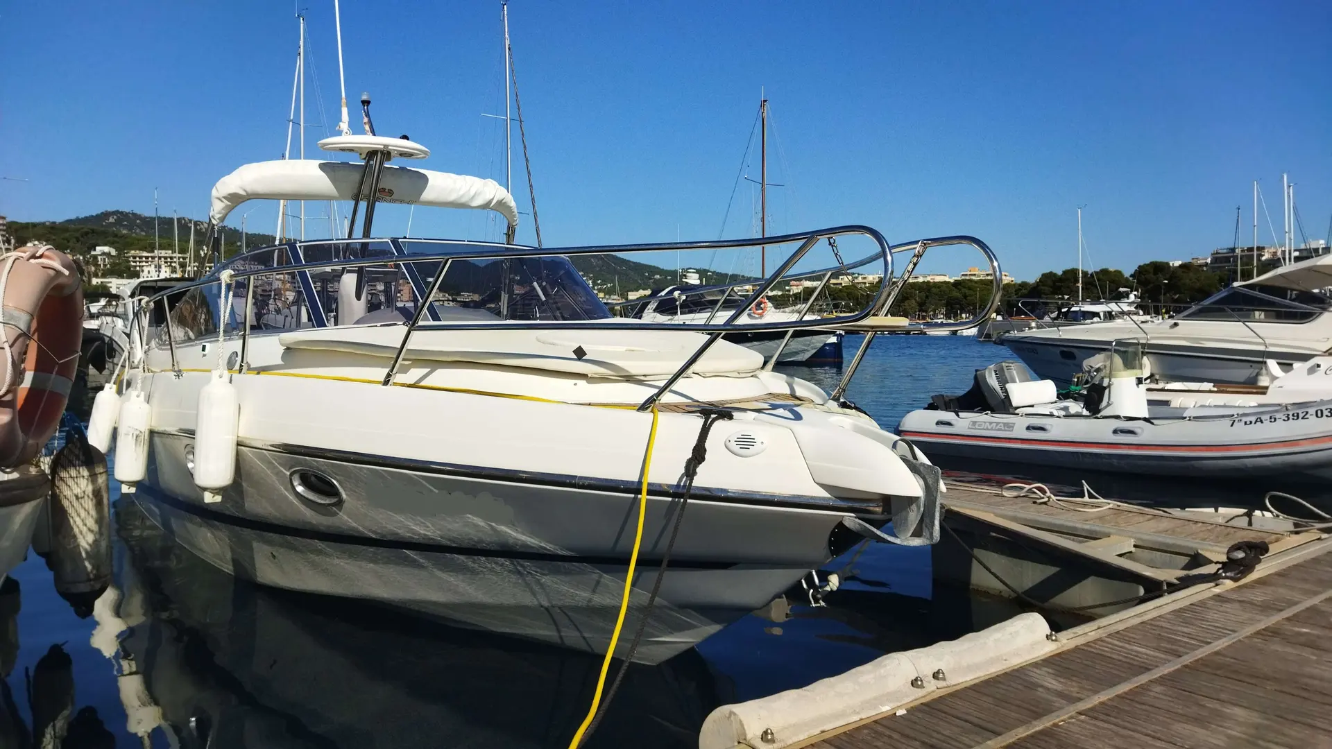 Cranchi CSL 28 — Bateau à moteur amarré dans un port, vu de trois quarts avant.