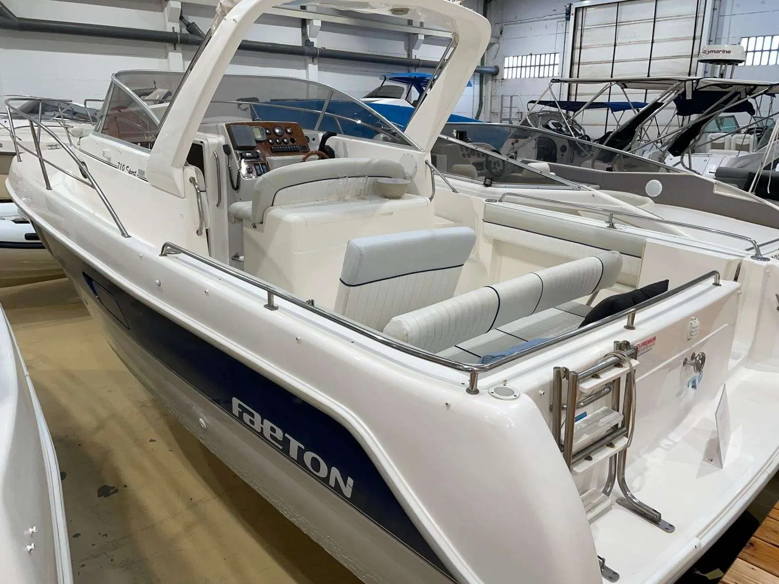 Faeton 780 Sport — Vue trois quarts arrière d’un bateau blanc exposé dans un hangar.