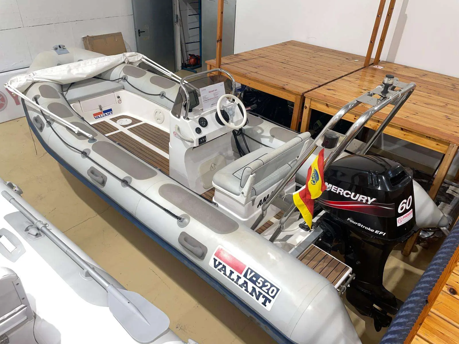 Valiant 520 Vanguard — Bateau pneumatique exposé en intérieur avec console centrale et moteur hors-bord.