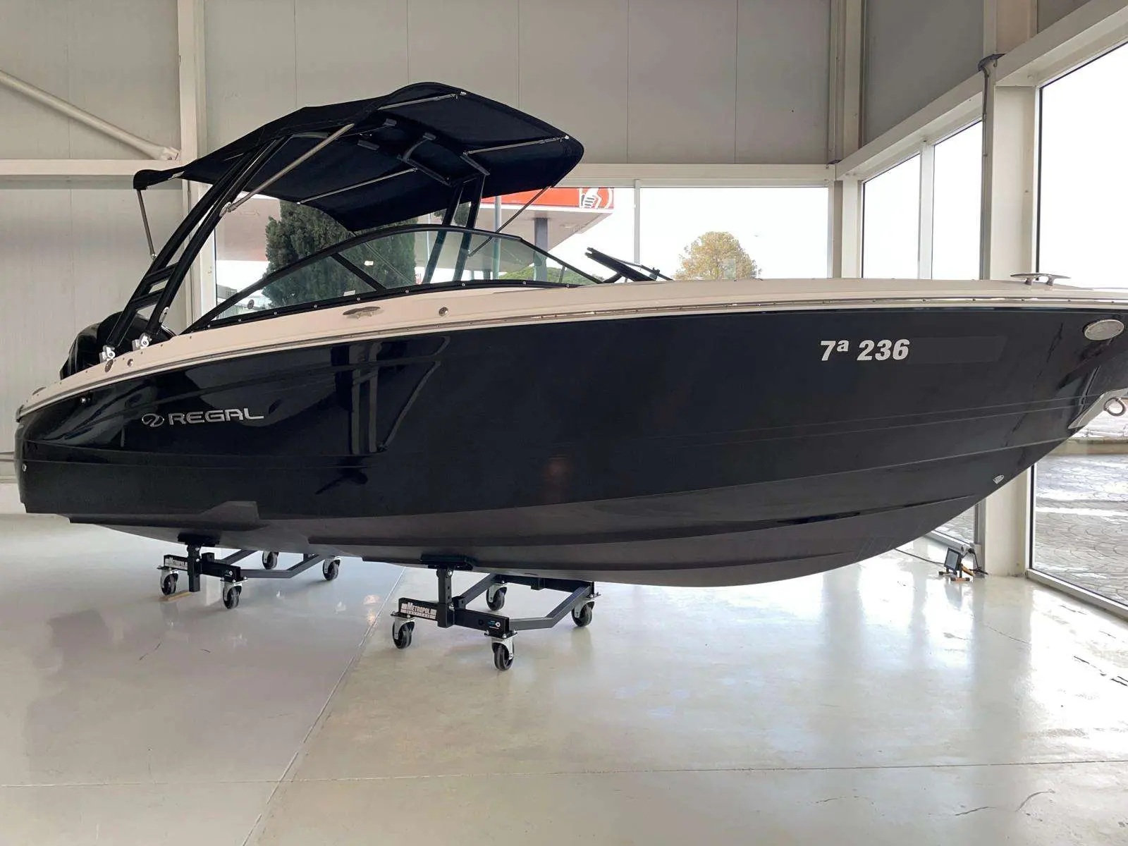 Regal LX2 — Bateau noir présenté sur remorque dans un showroom vitré.