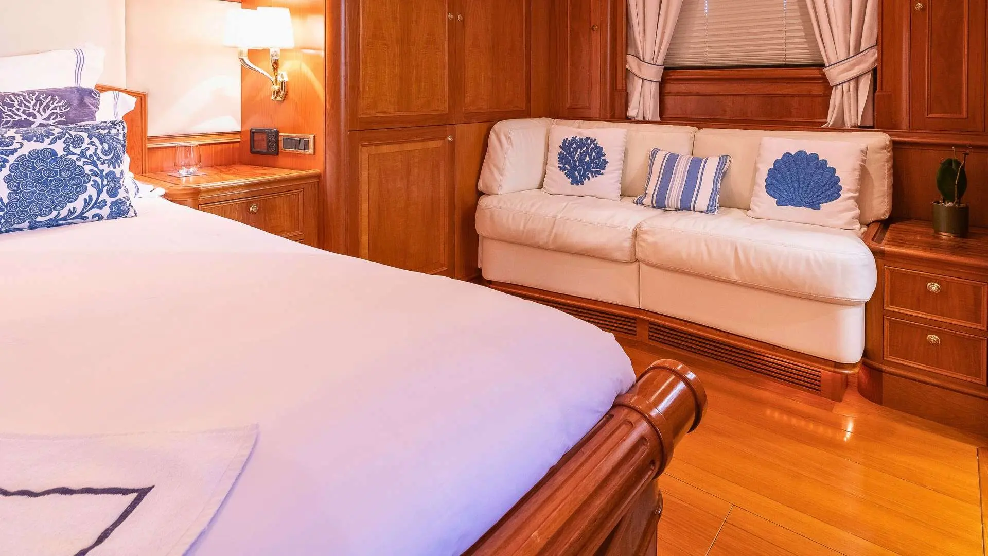 Nautor Swan Swan 112 — Cabine avec lit double, canapé et boiseries en bois verni.