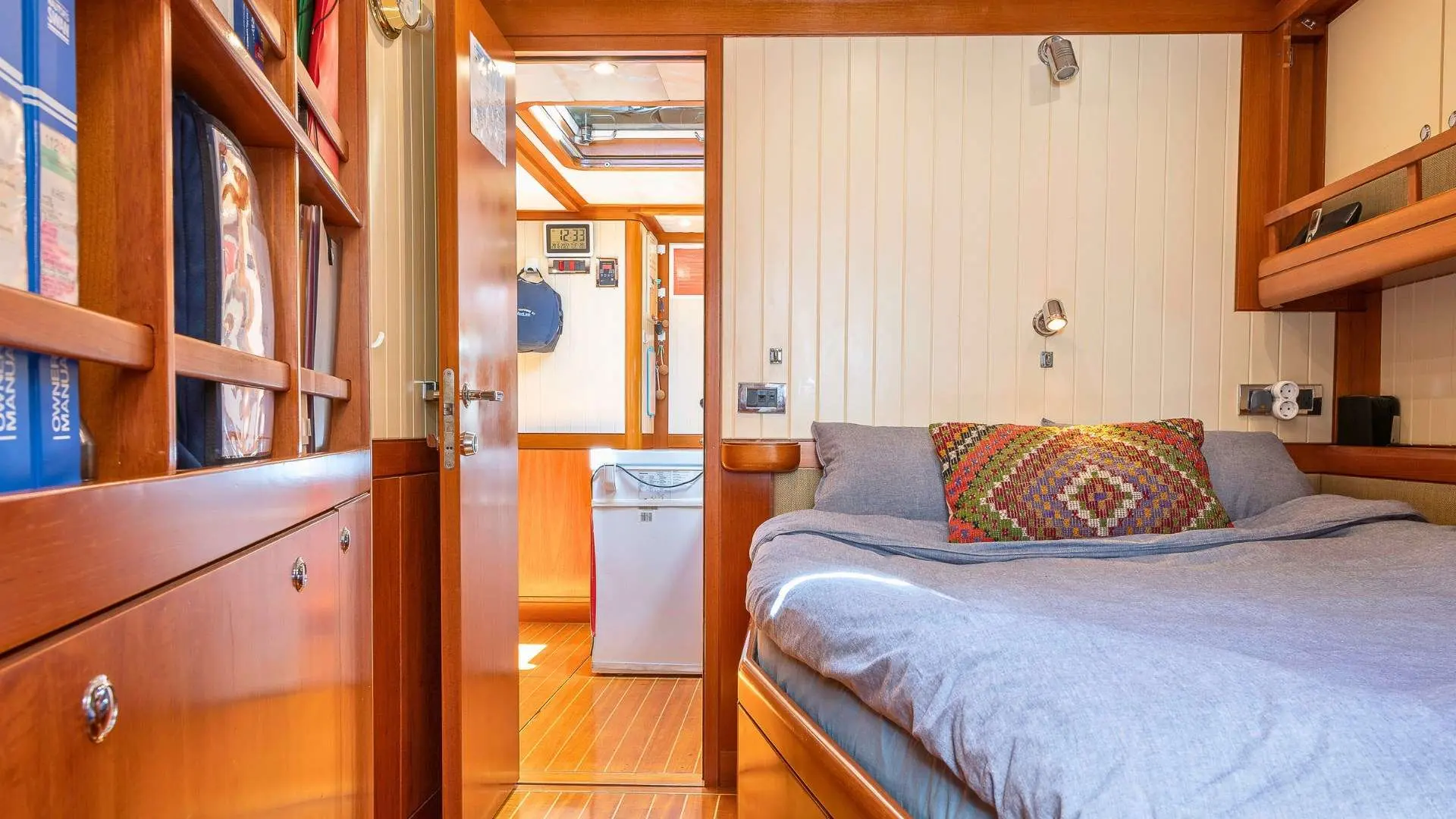 Nautor Swan Swan 112 — Cabine avec couchette double, rangements en bois et porte ouverte vers l'intérieur.