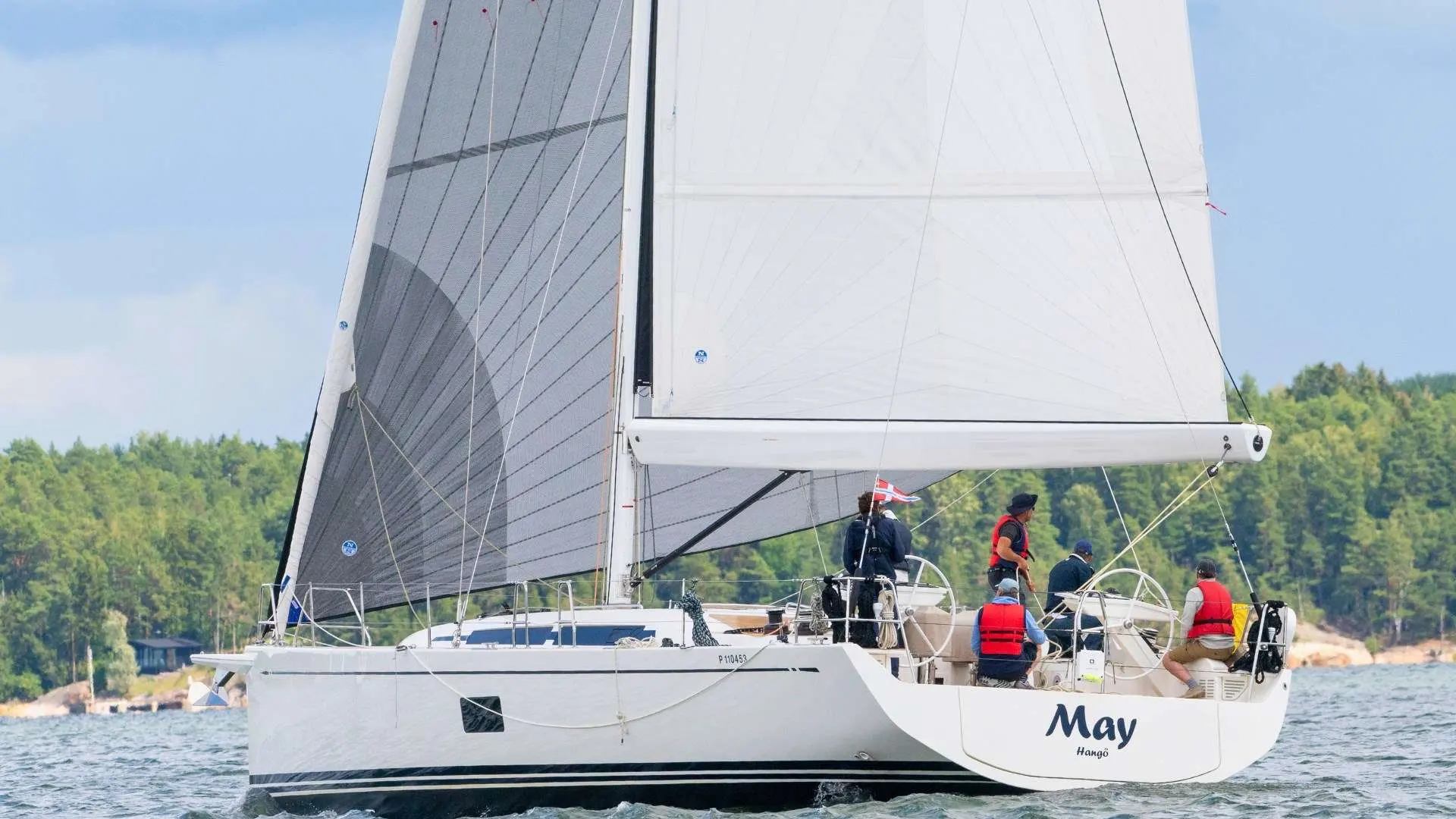Nautor Swan Swan 55 — Voilier blanc sous voiles, photographié de profil sur une eau calme.