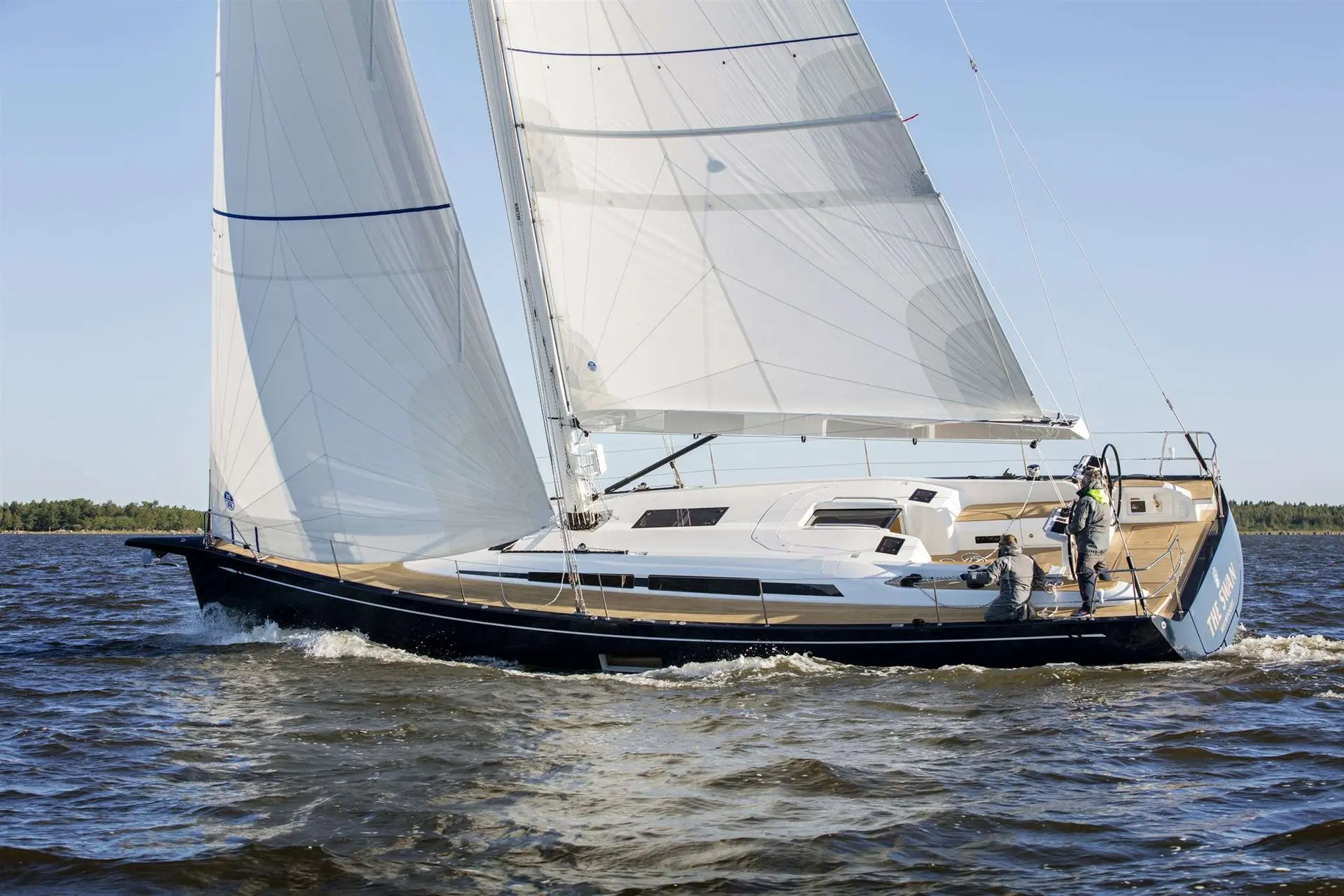 Nautor Swan Swan 48 — Voilier naviguant sous voiles, vu de profil, avec deux personnes dans le cockpit.
