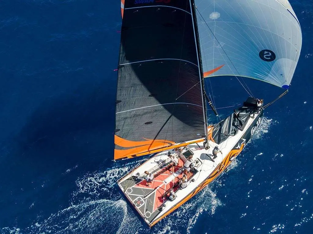Nautor Swan Swan 36 — Voilier de course vu du dessus, toutes voiles déployées sur une mer bleu profond.
