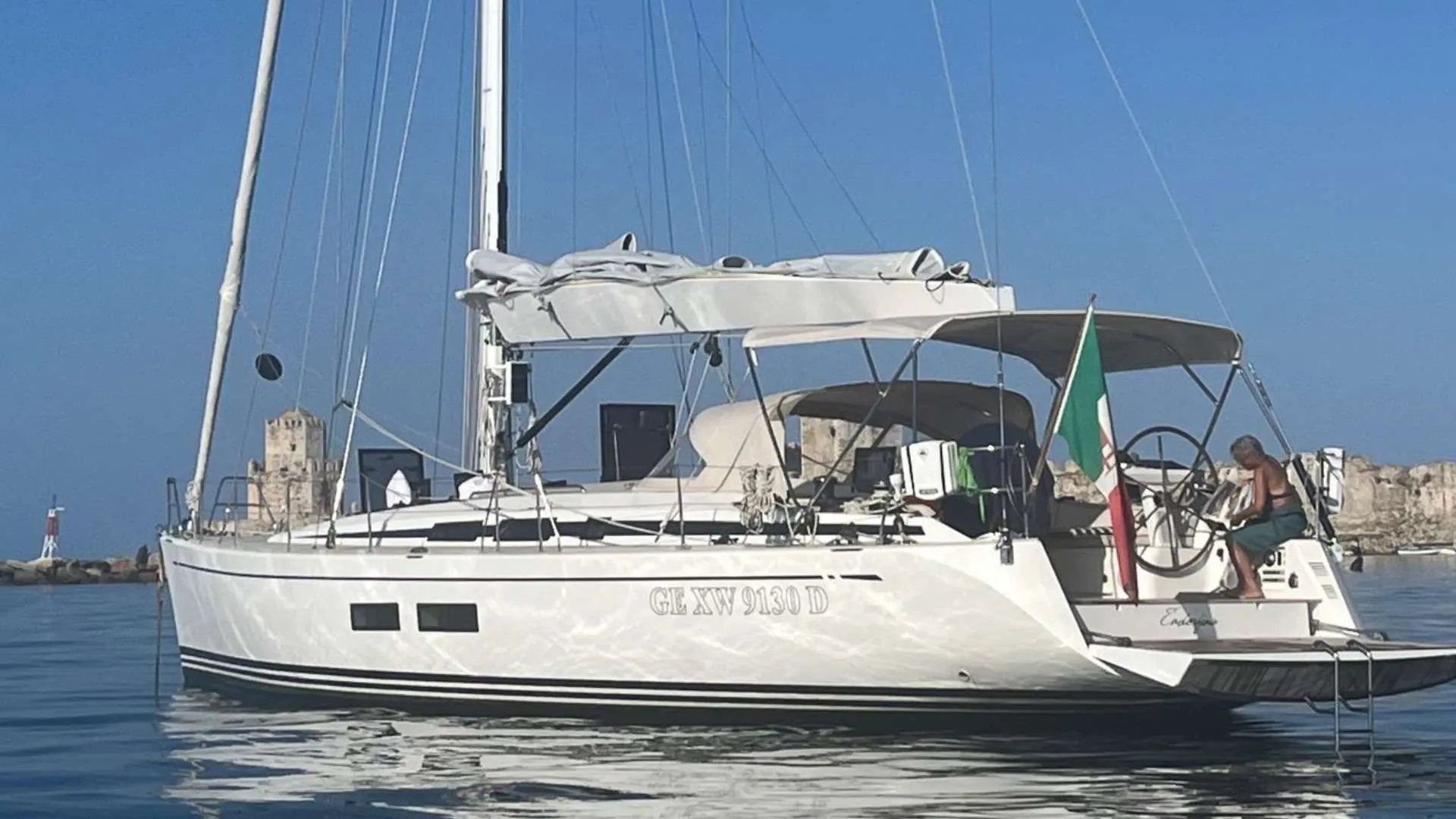 Nautor Swan Swan 54 — Voilier blanc vu de trois quarts au mouillage, avec une personne à la poupe.