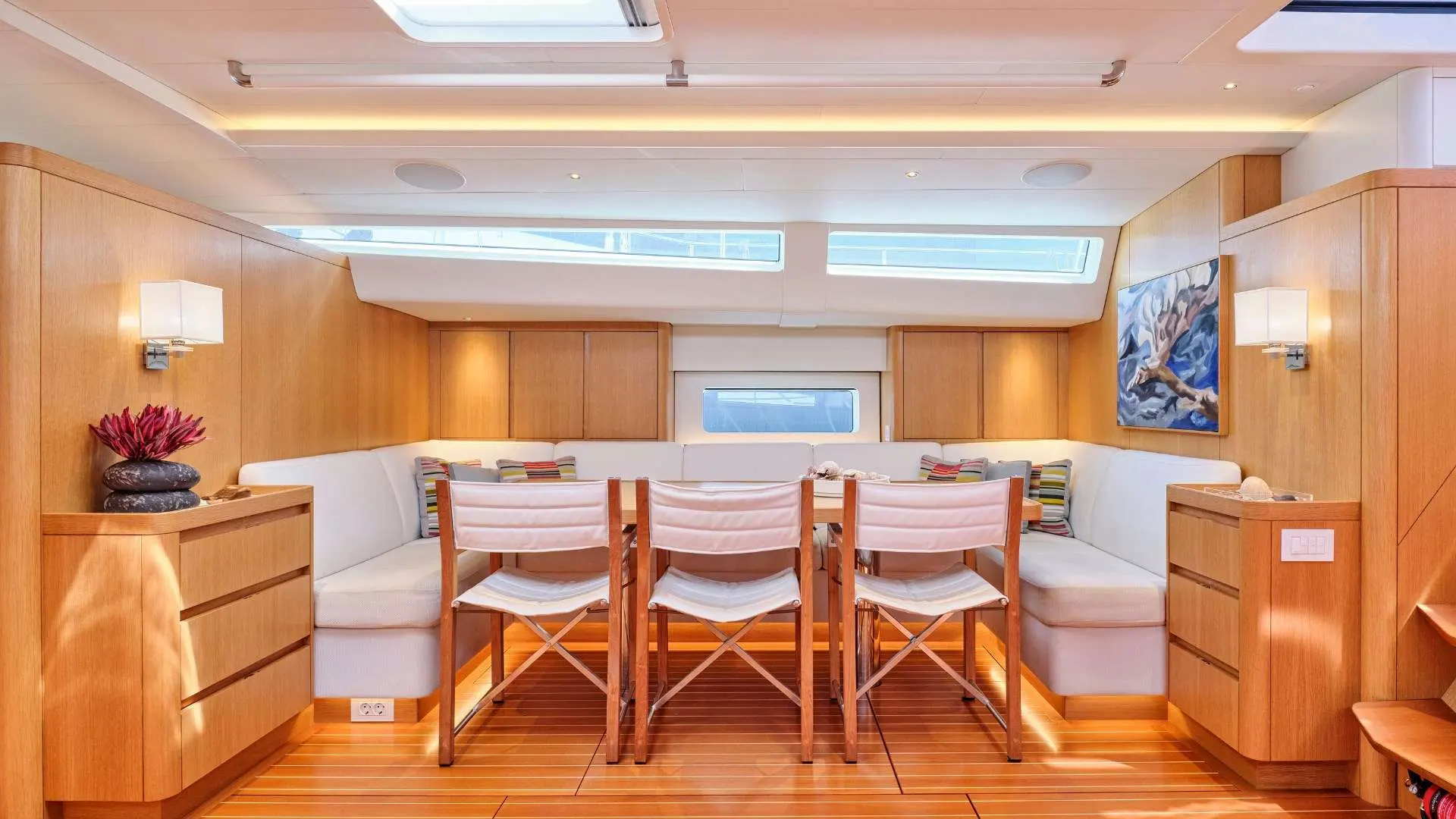 Nautor Swan Swan 78 — Salon intérieur avec banquettes et trois fauteuils autour d'une table.