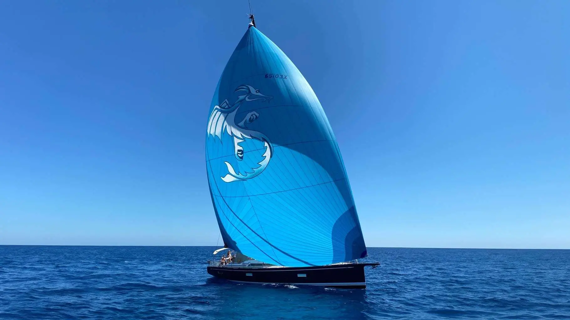 Nautor Swan Swan 65 — Voilier au large, vu de profil, naviguant sous une grande voile bleue.