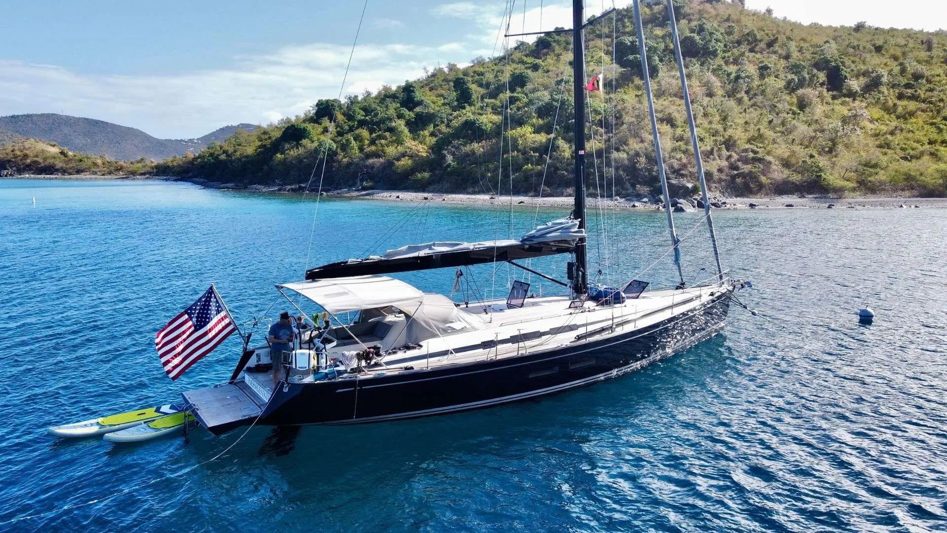 Nautor Swan Swan 54 — Voilier amarré dans une baie, avec des paddleboards à l'arrière.