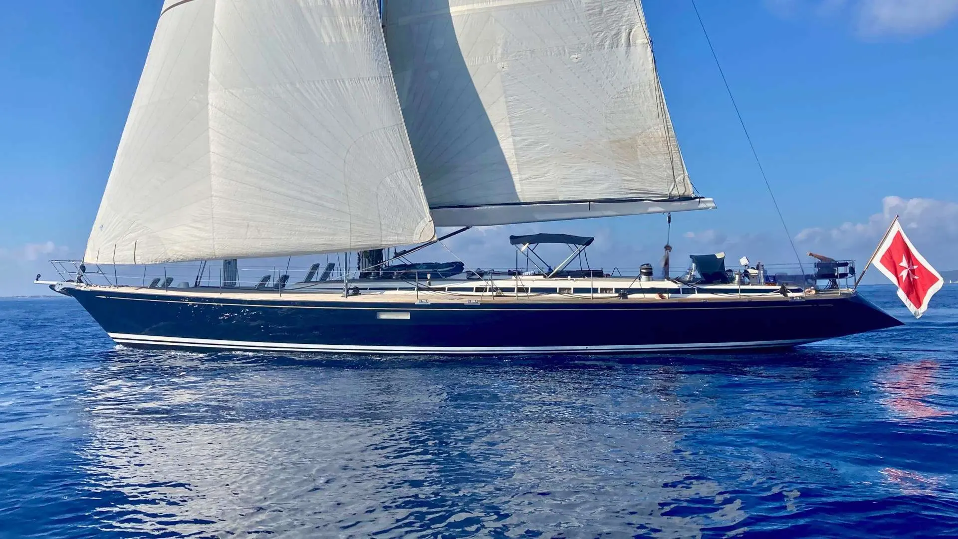 Nautor Swan Swan 77 — Voilier vu de profil sous voiles, naviguant sur une mer calme.