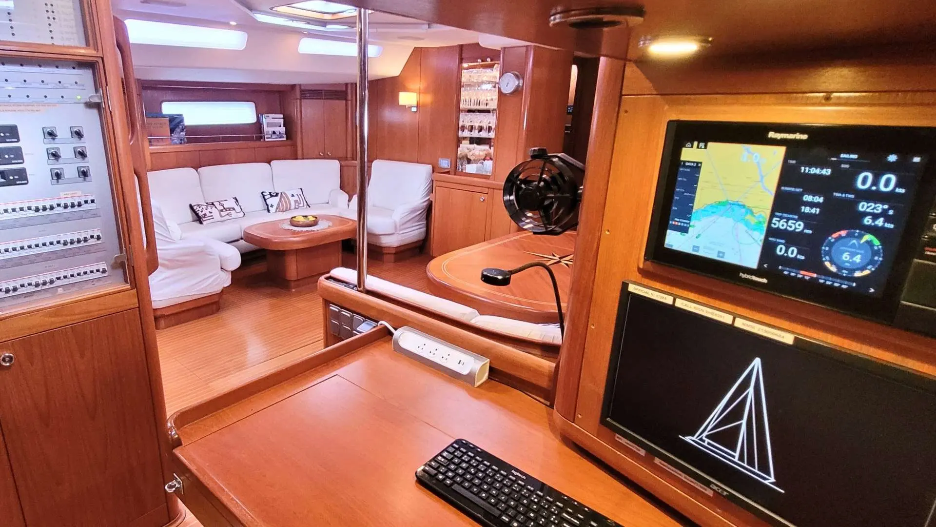 Nautor Swan Swan 77 — Vue intérieure du carré et de la table à cartes avec instruments de navigation.