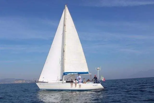Nautor Swan Swan 36 — Voilier blanc naviguant au large, vu de profil, avec plusieurs personnes à bord.