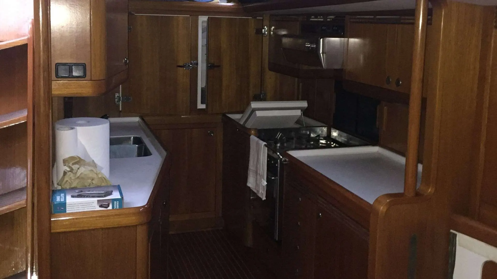 Nautor Swan Swan 60 — Vue intérieure de la cuisine en bois, avec évier, plans de travail et cuisinière.