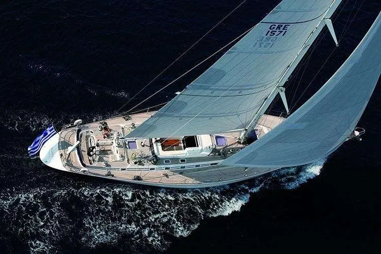 Nautor Swan Swan 77 — Voilier vu du dessus, toutes voiles dehors, naviguant sur une mer sombre.