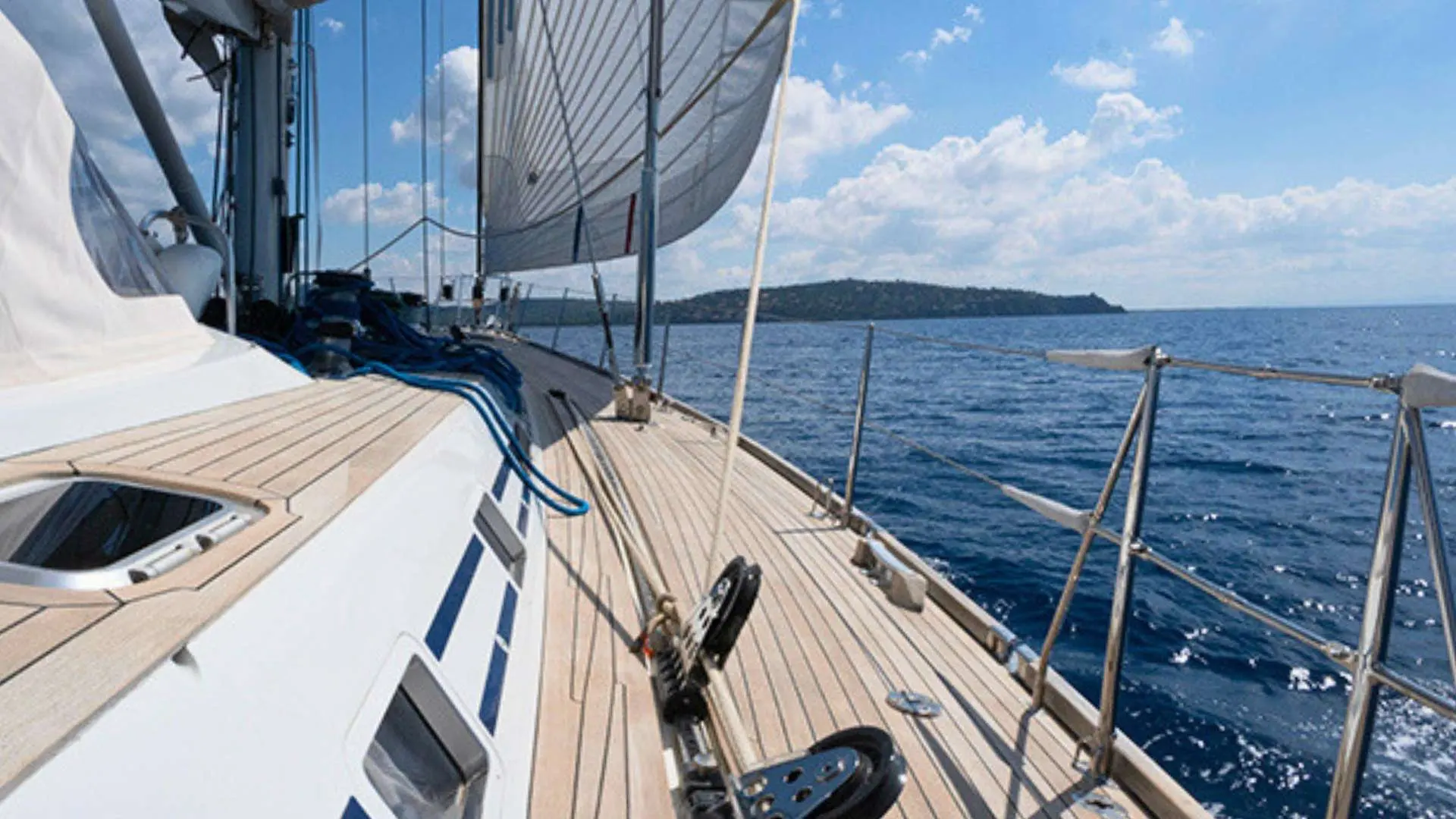 Nautor Swan Swan 77 — Vue du pont avant d'un voilier sous voiles, en mer par temps dégagé.