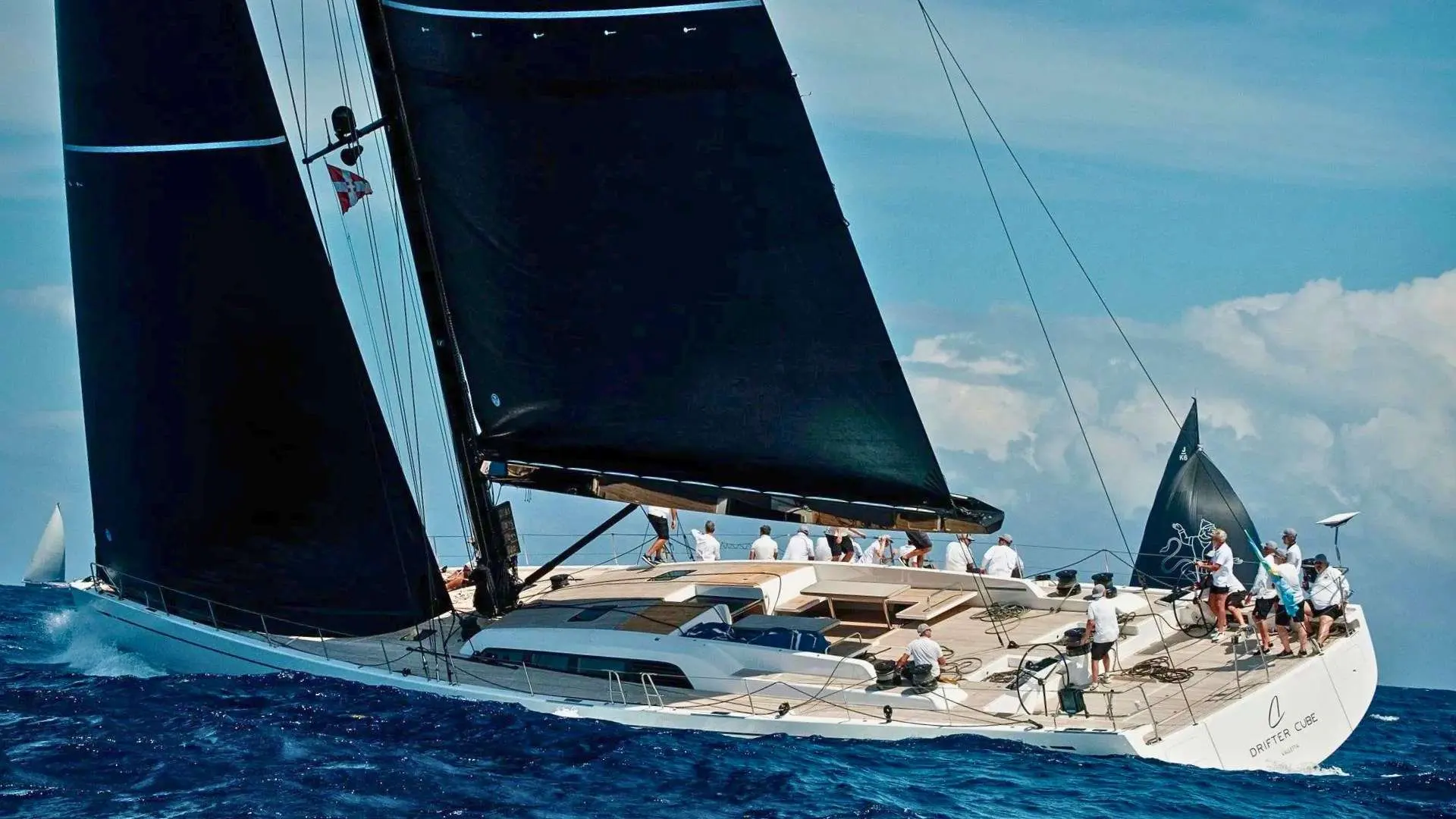 Nautor Swan Swan 98 — Voilier blanc à deux voiles noires naviguant au large par mer agitée.
