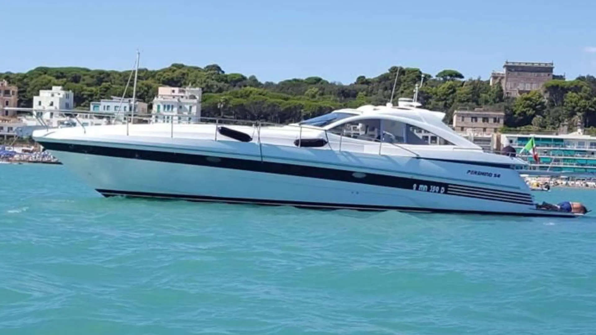 Pershing 54 — Vue latérale d’un bateau à moteur blanc près d’un port.