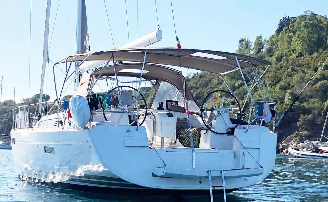 Jeanneau Sun Odyssey 509 — Voilier blanc vu de trois quarts arrière, avec cockpit à double barre et taud.