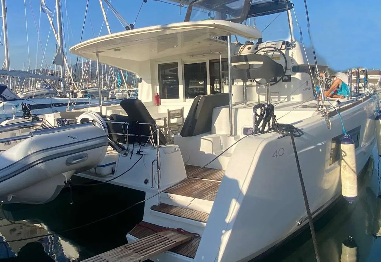 Lagoon 40 — Vue arrière d’un catamaran amarré, avec annexe et cockpit visibles.
