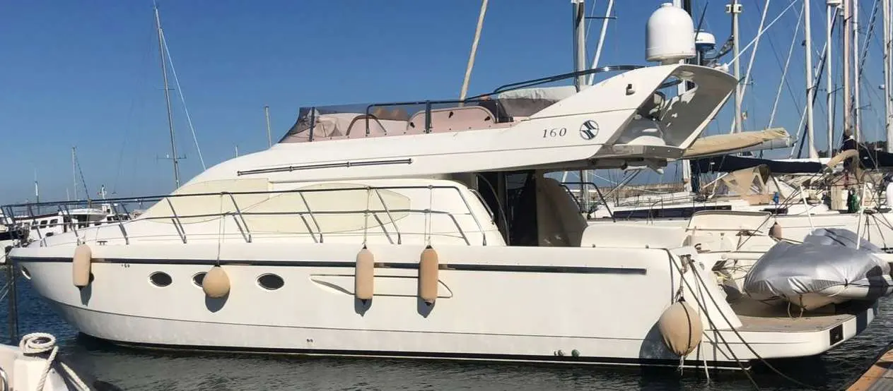 Carnevali 160 — Bateau à moteur blanc amarré dans une marina, vu de profil bâbord.
