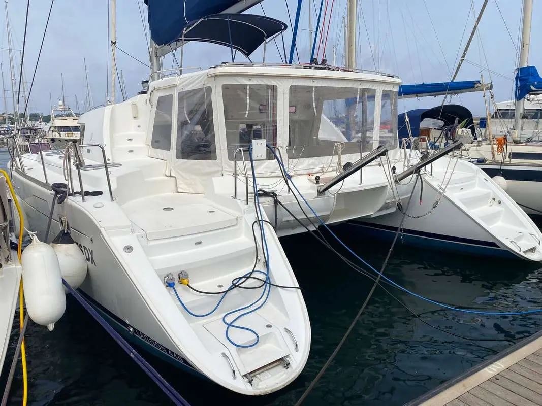 Lagoon 440 — Catamaran blanc amarré au port, vu de trois quarts depuis le quai.