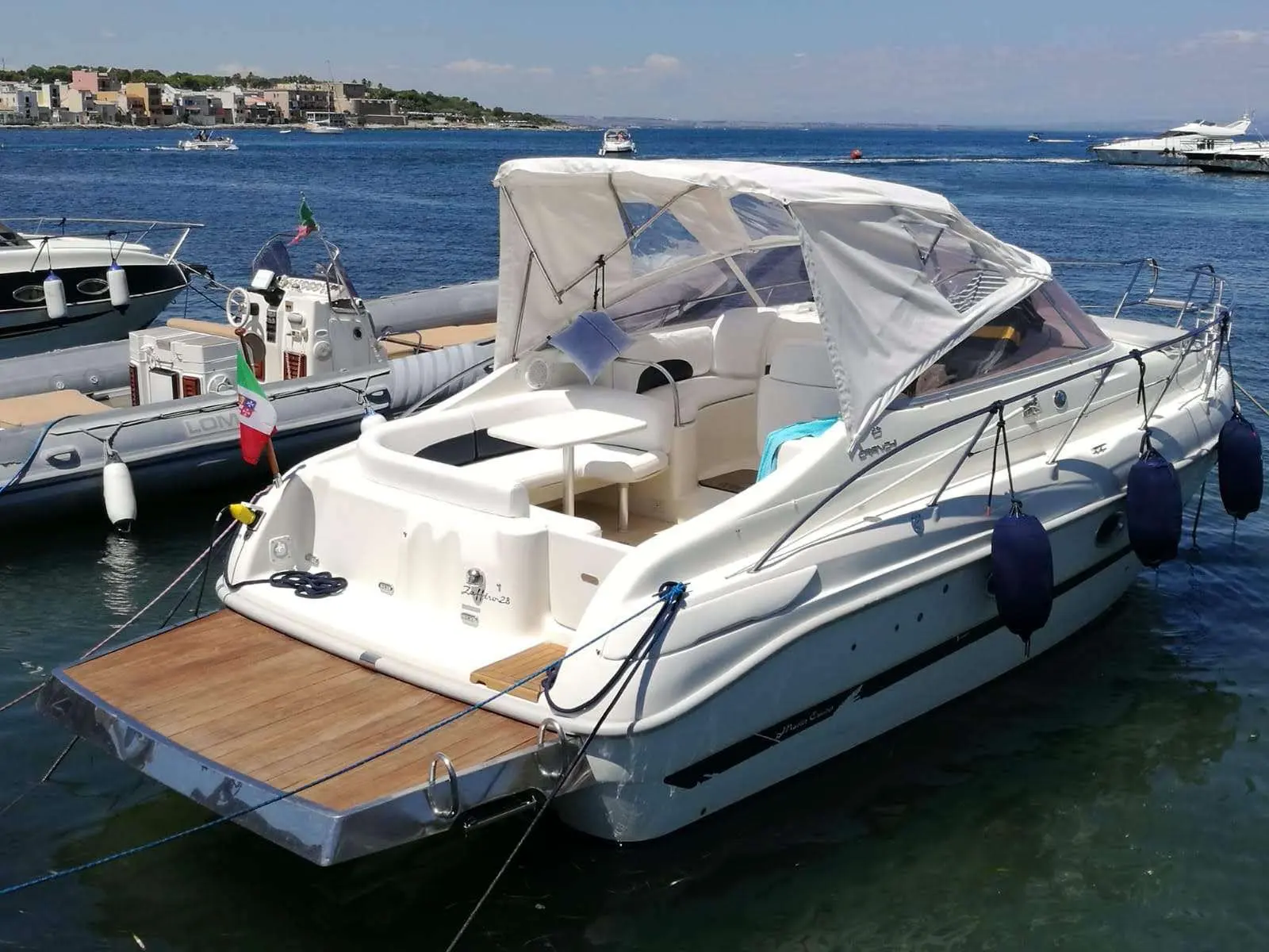 Cranchi Zaffiro 28 — Bateau à moteur blanc amarré dans une marina, vu de trois quarts arrière.