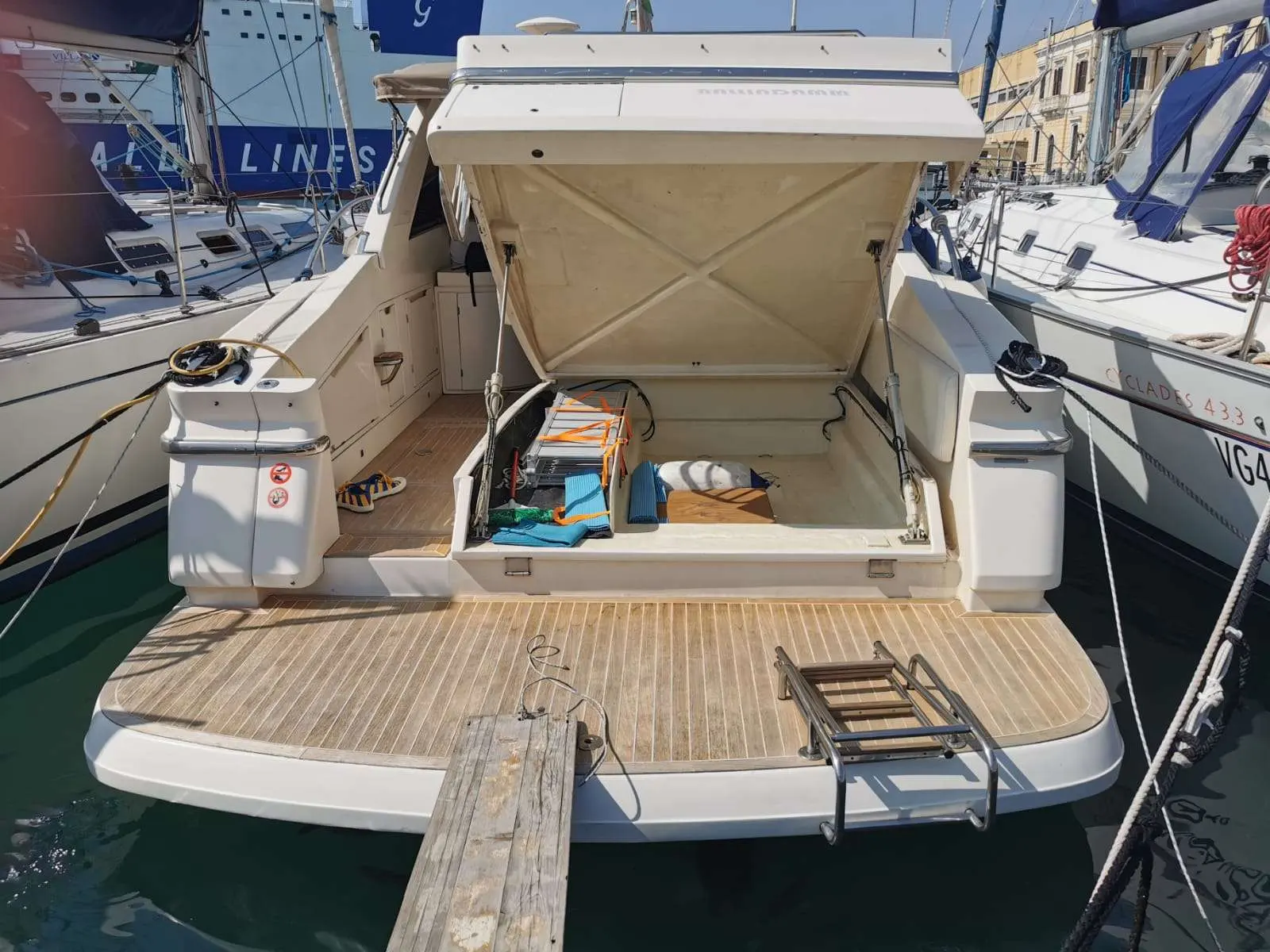 Ilver 39 Mirable — Vue arrière d’un bateau amarré, avec le garage ouvert et la plateforme arrière visible.