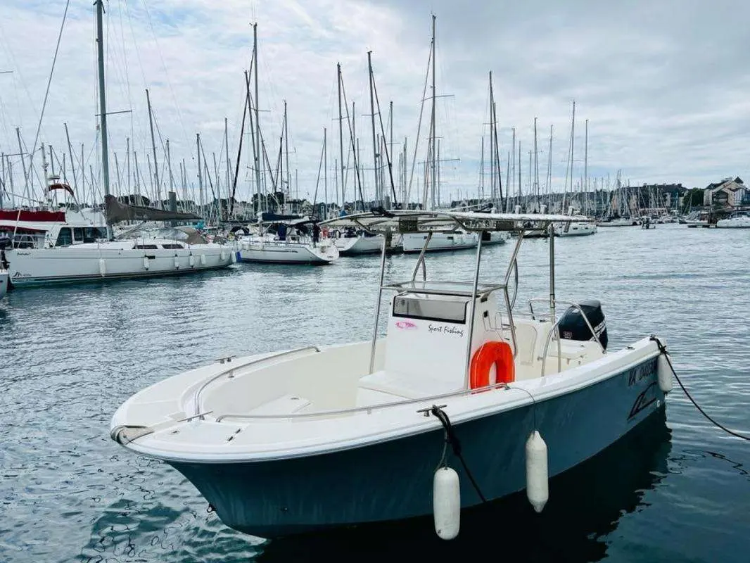 Uniquest Marine Uniquest 600 — Bateau à console centrale amarré dans une marina, photographié de trois quarts avant.