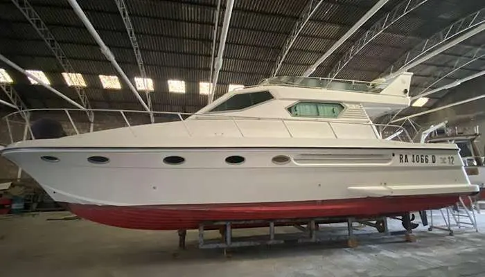Della Pasqua DC 12 — Bateau à moteur blanc photographié de profil dans un hangar, posé sur berceau.