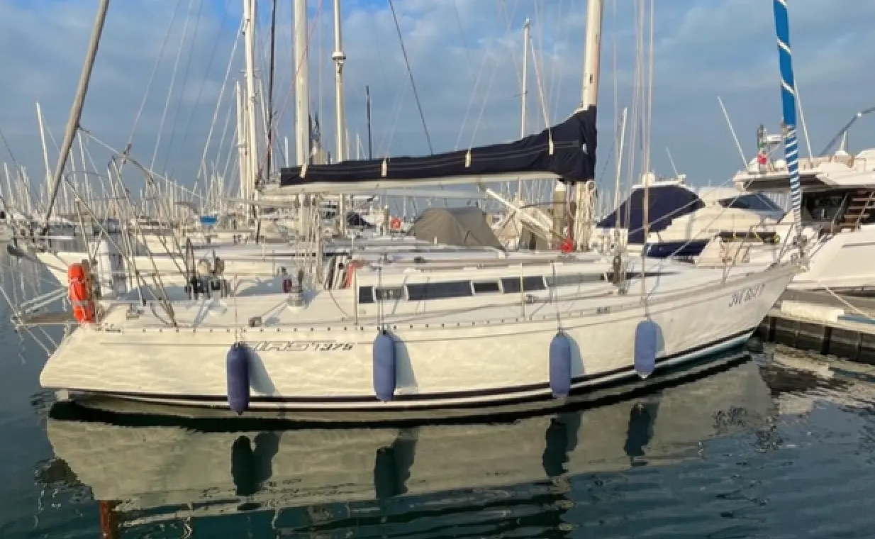 Beneteau First 375 — Voilier blanc amarré dans une marina, vu de profil sur l’eau.