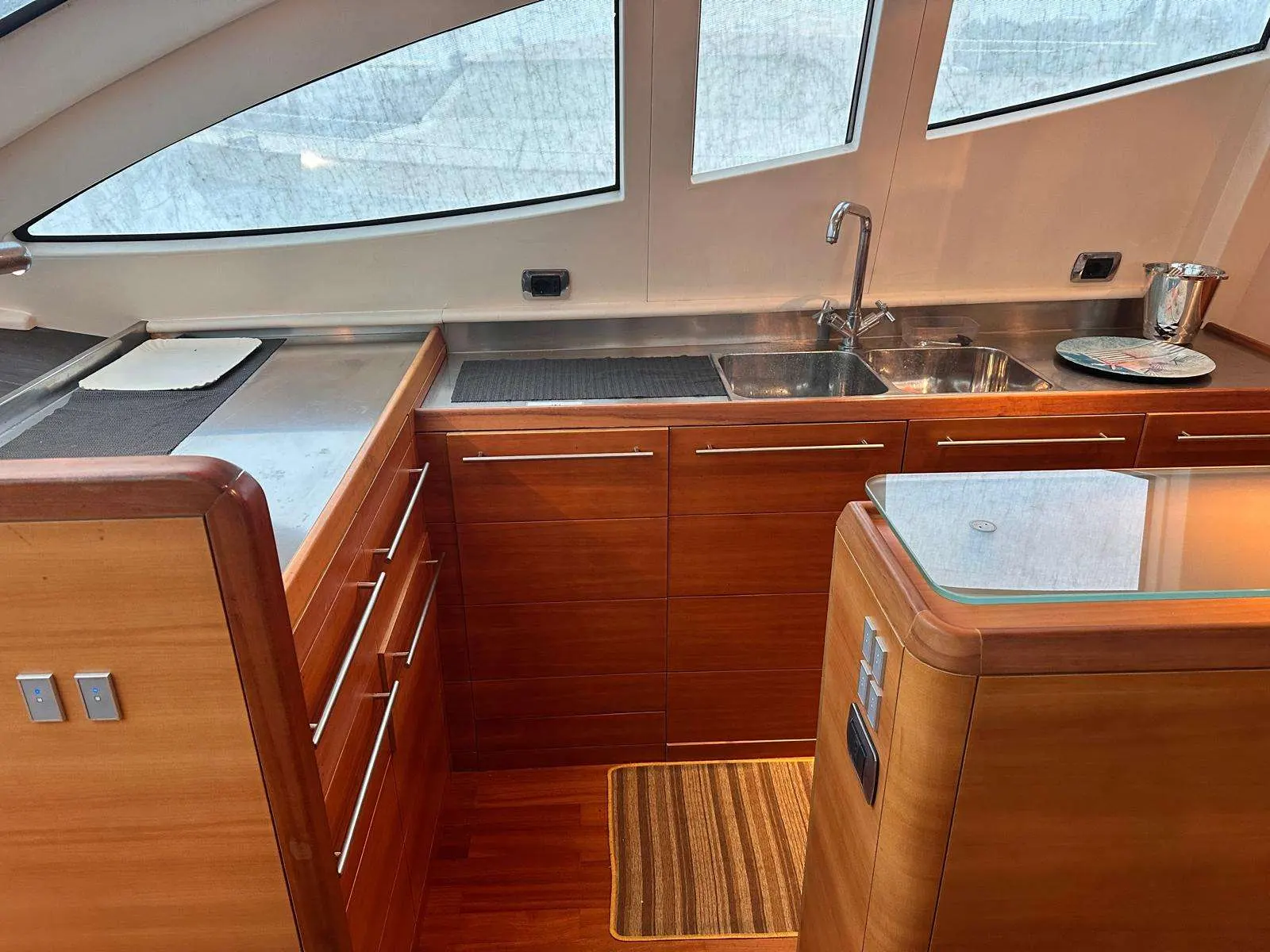 Aicon 64 Fly — Cuisine intérieure avec évier double, mobilier en bois et plans de travail.