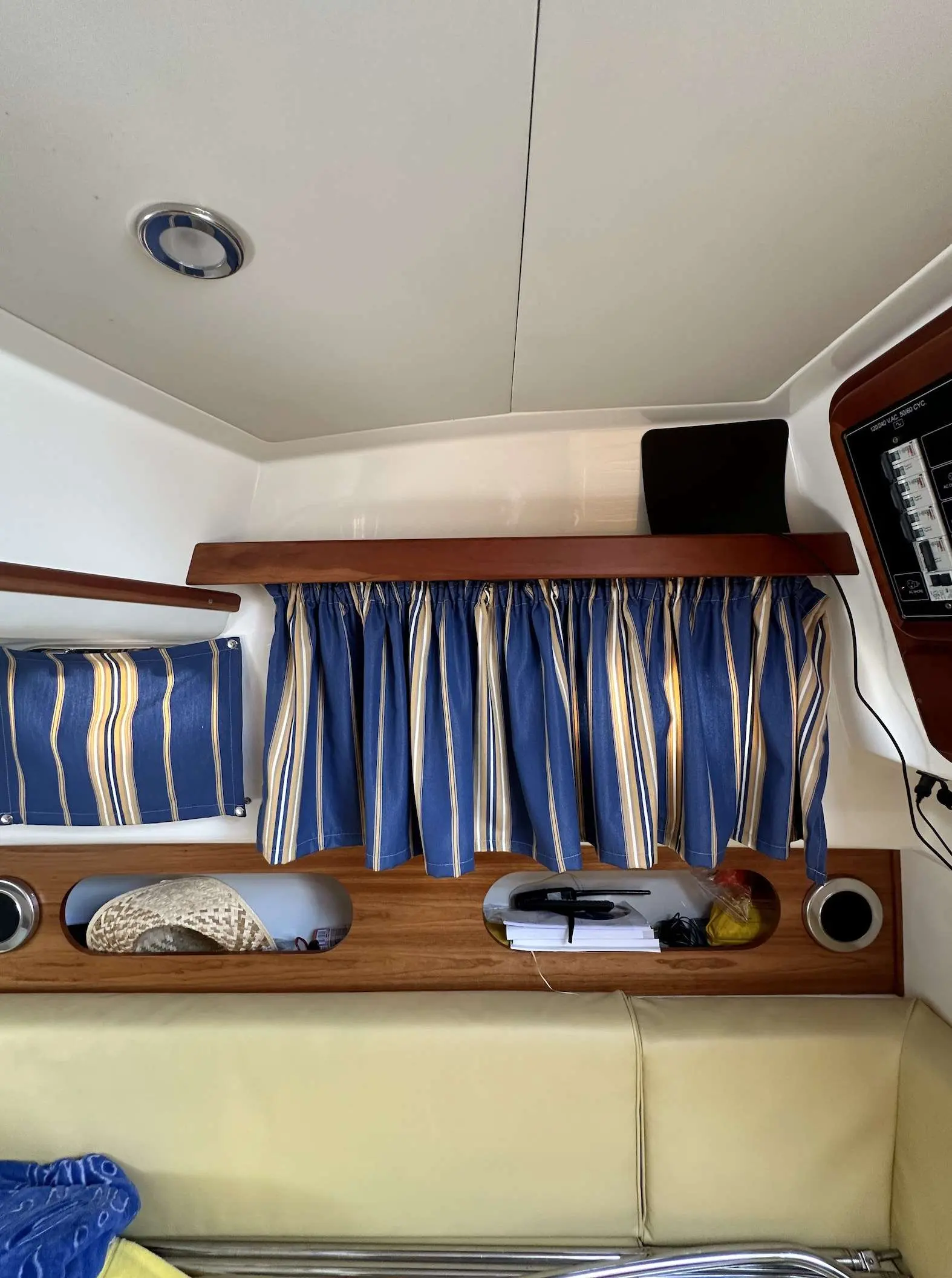 Apreamare 28 Semi Cabinato — Vue intérieure d'un salon avec banquette, rideaux et panneau de commande.