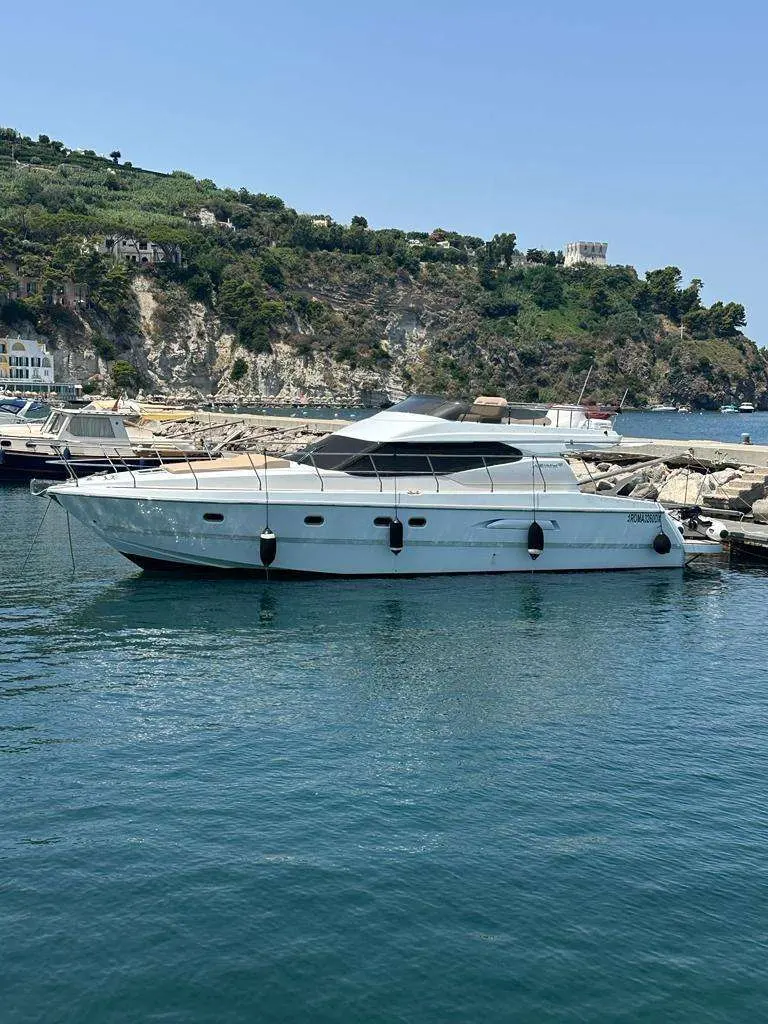 Azimut 43 — Bateau à moteur blanc amarré dans une baie rocheuse.