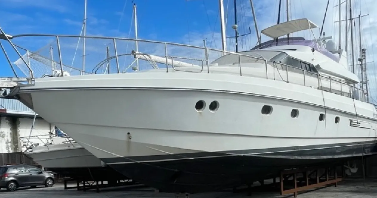 Mochi 56 — Yacht à moteur blanc photographié à terre, vu de trois quarts avant.