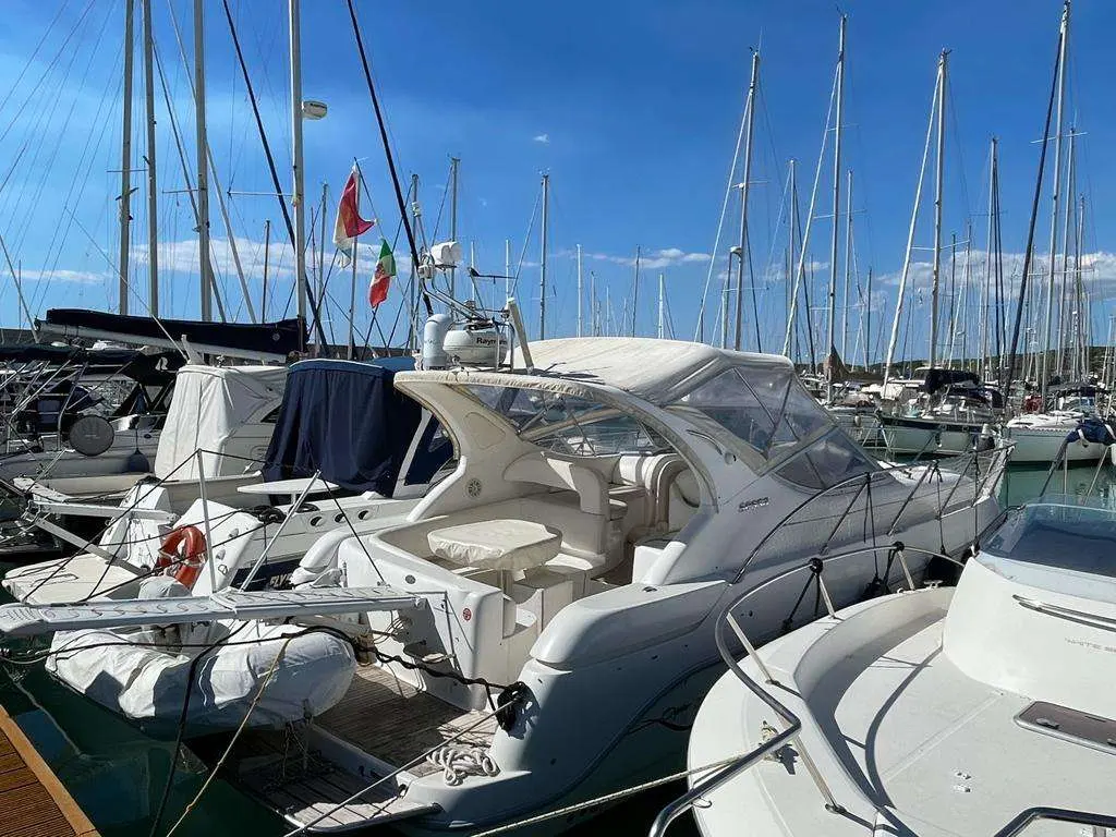 Sessa Marine Oyster 35 — Bateau à moteur blanc amarré dans un port de plaisance, entouré de voiliers.
