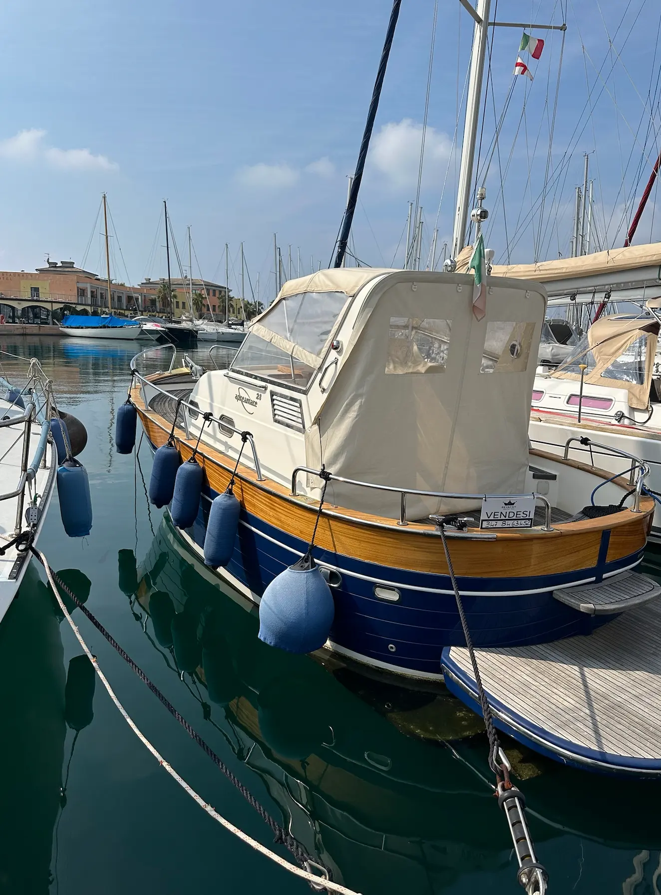 Apreamare 28 Semi Cabinato — Bateau à moteur bleu et blanc amarré dans un port de plaisance.