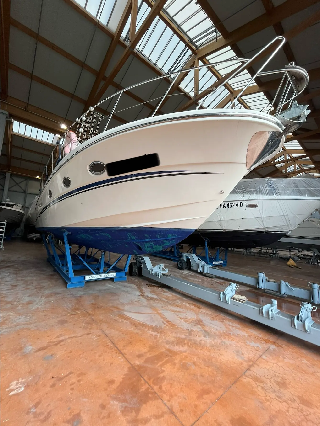 Innovazioni E Progetti Mira 40 — Bateau à moteur vu de l’avant, posé sur une remorque dans un hangar.