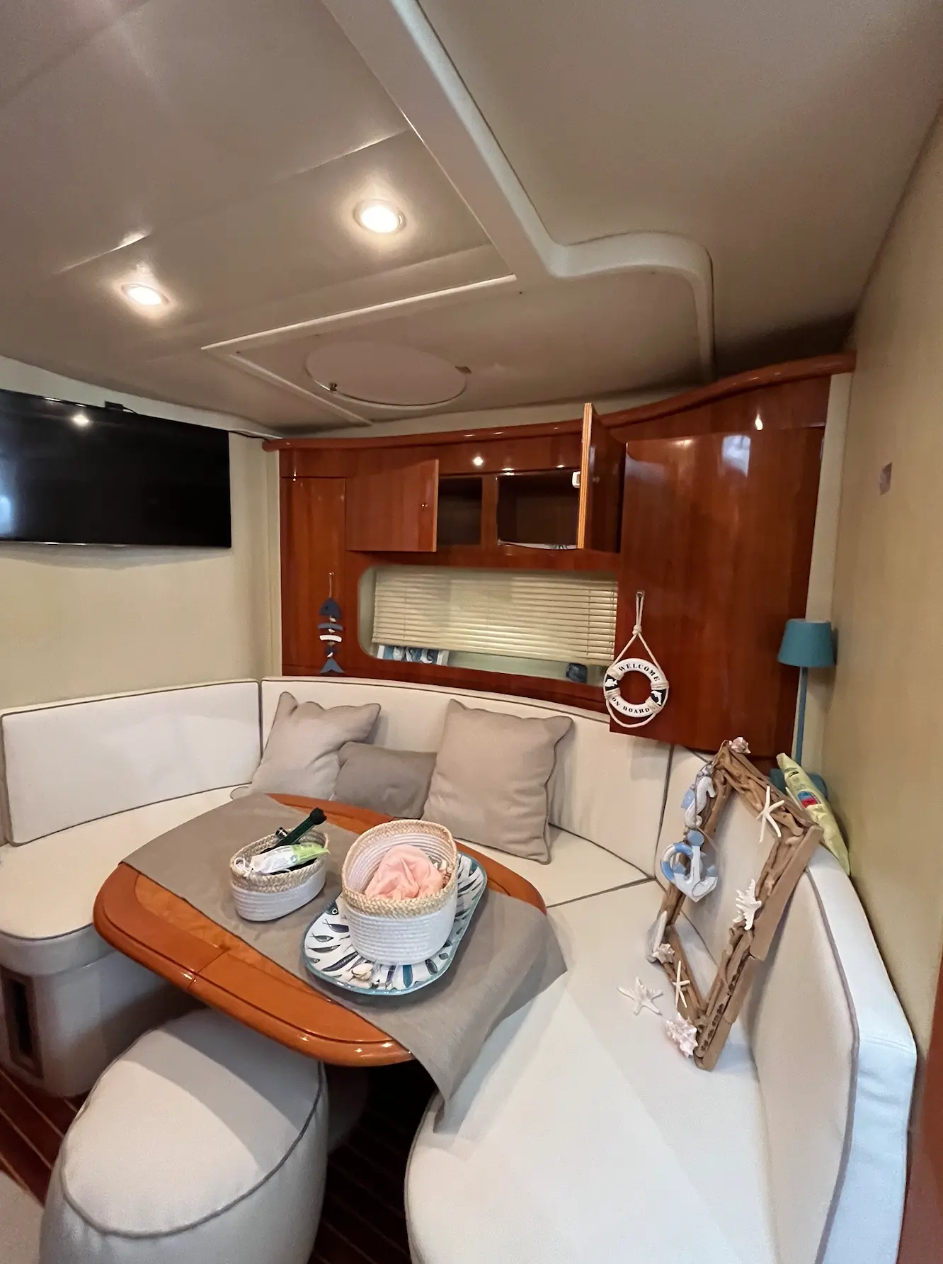 Innovazioni E Progetti Mira 40 — Salon intérieur avec banquette en U, table et rangements en bois.