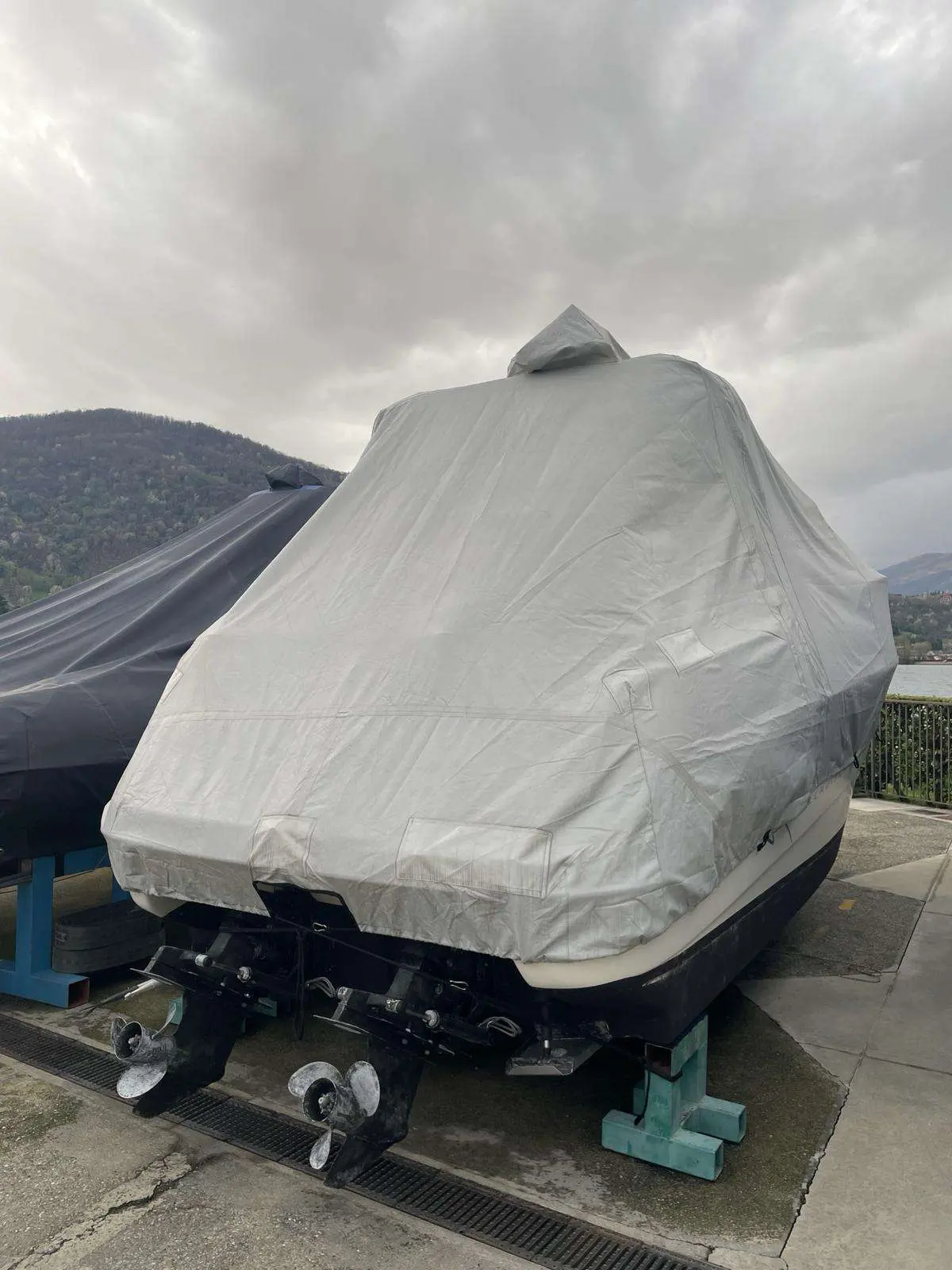 Sessa Marine Oyster 27 — Bateau bâché vu de l’arrière, avec deux embases et hélices apparentes.